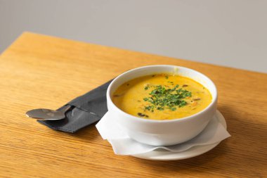 Kafedeki ahşap masada yeşil kişniş otuyla Tayland usulü köri çorbası. Geleneksel Tayland baharatlı yemekleri. Sağlıklı beslenme konsepti. Asya restoranında yemek zamanı..