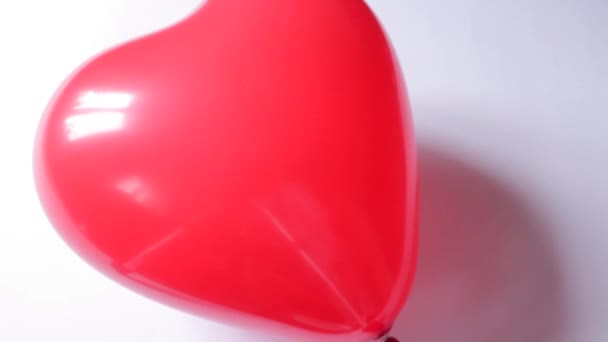 心臓の形で赤い飛行気球は 画面を下に移動し 完全に消え 白い背景に隔離されます 愛とお祝いのバレンタインデーの概念 休日の販売と広告 — ストック動画