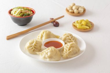 Kaynamış hamur köftesi, manti ya da hamur tatlısı, kıymalı et ve yanında da yemek çubuğu, mantar turşusu, lahana salatası ve acı biber. Ev yapımı yemek.