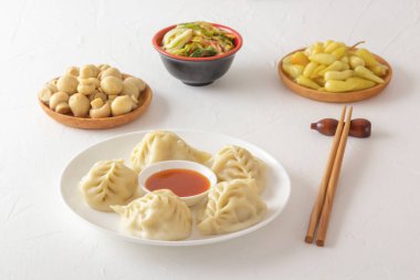 Kaynamış hamur köftesi, manti ya da hamur tatlısı, kıymalı et ve yanında da yemek çubuğu, mantar turşusu, lahana salatası ve acı biber. Ev yapımı yemek.