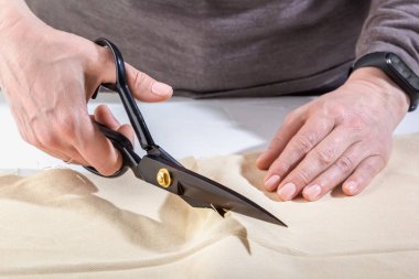 Bir kadının elindeki terzi makası kumaşı kesti.