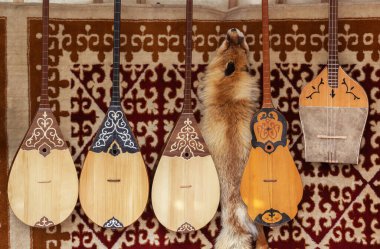 Kazak ulusal el yapımı, at kılı telli müzik aletleri yurdun keçeli duvarında satılık duruyor..