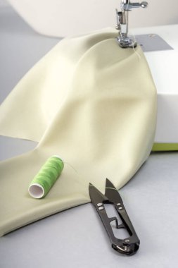 Bir kumaş parçası ve dikiş aksesuarlarıyla iplikleri kesmek için terzi makası. Yukarıdan görüntüle