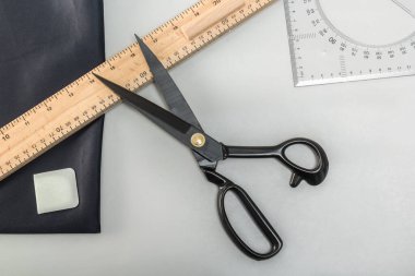 Masanın üzerinde terzi makası, desenler, işaretler ve kesikler var. Yukarıdan görüntüle