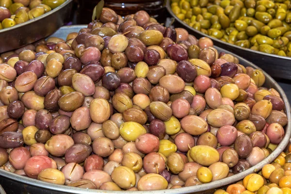 Multi-colored olives are sold at the street market. Close-up