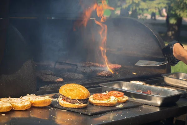 在公园里一家街头餐馆的烤架上做汉堡包 — 图库照片