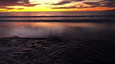 Sunset on the Pacific ocean. Waves roll on the beach.