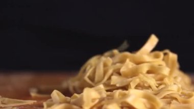 Ev yapımı yumurta makarnası hazırlıyorum. Kadın eli kaldırır ve makarnayı masaya fırlatır. Yüksek kaliteli FullHD görüntüler