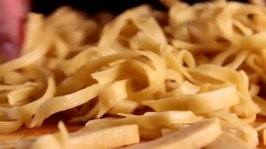 Ev yapımı yumurta makarnası hazırlıyorum. Kadın eli kaldırır ve makarnayı masaya fırlatır. Yüksek kaliteli FullHD görüntüler