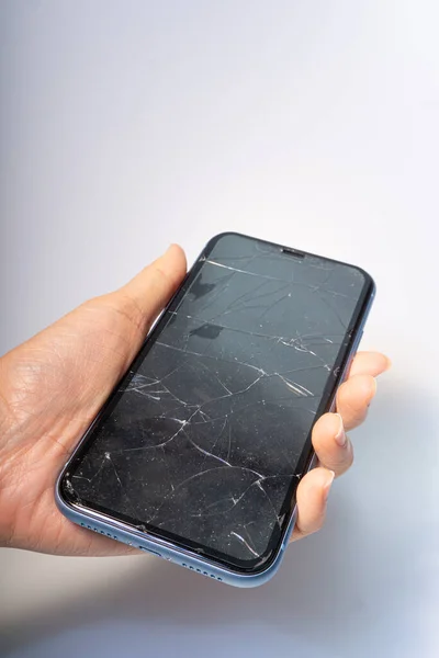 Beyaz arkaplanda kötü hasar görmüş bir ekranı olan akıllı telefon