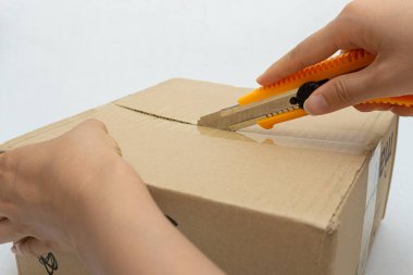 Unboxing the courier box with a cutter knife