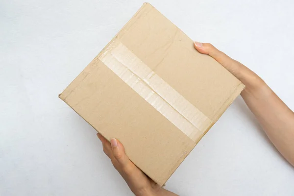 Kesici bir bıçakla kurye kutusunu açıyor.