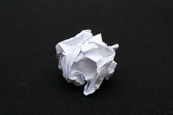 Siyah arka planda buruşmuş kağıt çöpleri.