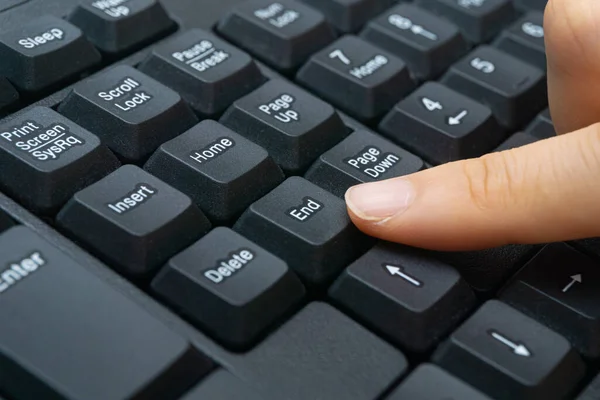 A woman\'s finger holding a computer keyboard