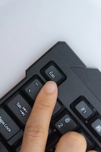 A woman\'s finger holding a computer keyboard