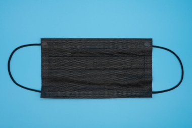 Mavi arkaplanda çeşitli renklerde tek kullanımlık koruyucu maskeler