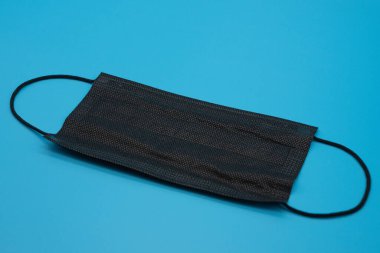 Mavi arkaplanda çeşitli renklerde tek kullanımlık koruyucu maskeler