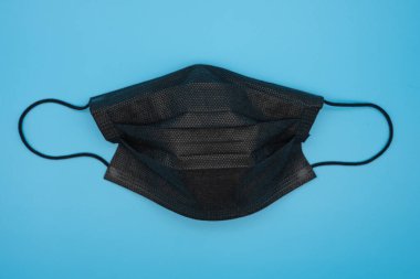 Mavi arkaplanda çeşitli renklerde tek kullanımlık koruyucu maskeler