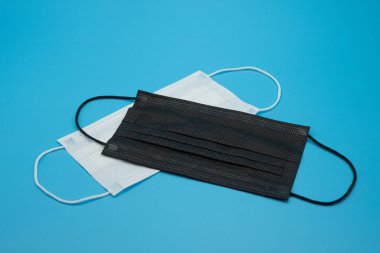 Mavi arkaplanda çeşitli renklerde tek kullanımlık koruyucu maskeler