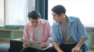 İki genç iş ortağı bir dizüstü bilgisayarda birlikte çalışarak araştırma sonuçlarını analiz ediyor ve işyerindeki verileri kontrol ediyorlardı..