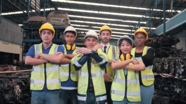 Çok ırklı endüstriyel işçi takımının grup portresi, teknisyenler, mühendisler, kullanılmış otomobil parçaları fabrikasında kamera görünümlü miğfer üniforması giyen teknisyenlerden oluşuyor. Endüstriyel işçi konsepti