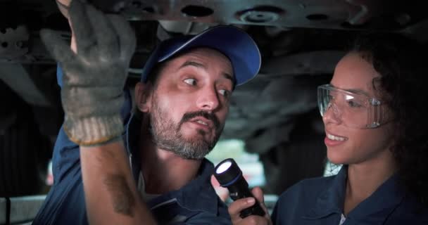 二名机械师穿着制服在汽车维修中与升降车辆一起工作 汽车维修和保养 在汽车服务中心工作的汽车技师 — 图库视频影像