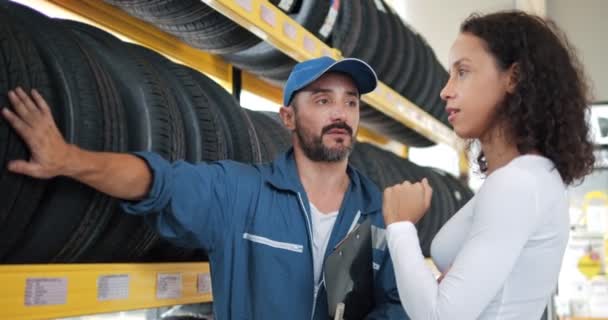 车胎销售人员通过向顾客讲述产品的特性来考察汽车维修车间中的分类情况 — 图库视频影像