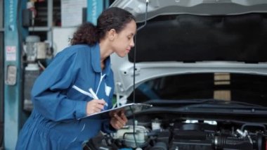 Otomobil tamircisi kadın garajda çalışan bir hizmet panosu tutuyor. Garajda çalışan deneyimli araba servis teknisyeni. Otomatik Servis Merkezi TemasıComment