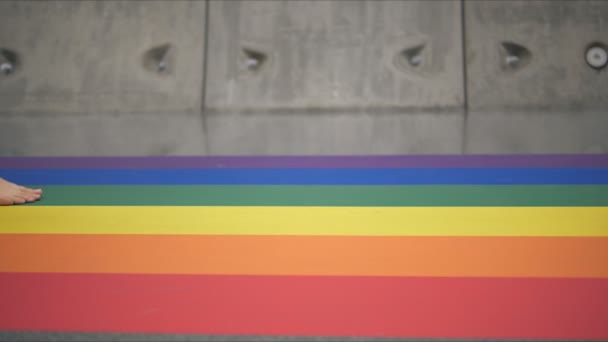 Lgbtの虹色の横断歩道を裸足で歩く足のスローモーション 誇りの月と自己肯定の概念 — ストック動画