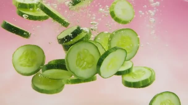 Fatias Pepino Verde Fresco Caindo Respingo Água Fundo Rosa Legumes — Vídeo de Stock