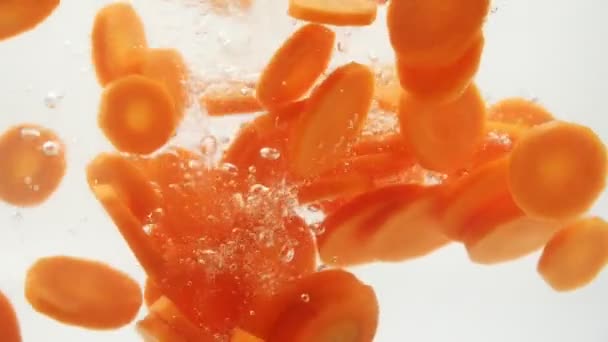 Slow Motion Fresh Orange Carrot Slices Falling Water Splash White — Vídeo de stock