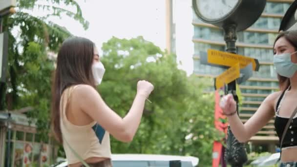 アジアの女性保護医療面マスクの2人の友人は肘を迎える 社会的距離 エルボーバンプは コロナウイルスやCovid 19の拡散を避けるために新しい挨拶です — ストック動画
