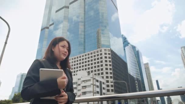 中央ビジネス街のローアングルのビュービルから超高層ビルで働くために歩くスーツ姿のアジアの従業員ビジネス女性の側面図現代都市 — ストック動画