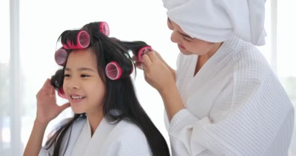 快乐的亚洲小女孩 妈妈用卷发梳头 一起坐在床上 家庭与美感 — 图库视频影像
