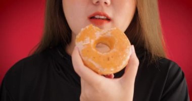 Çörek yiyen bir kadının ağzını kapat. Sevgi dolu, zevkli pastalar, tatlı, şeker bağımlılığı sağlıksız yemekler, kalori yiyecekler. Pastane, tatlı yemek mutluluk konsepti.