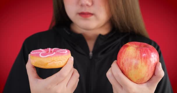 Close Mulher Posando Isolado Sobre Fundo Vermelho Escolher Entre Donuts — Vídeo de Stock
