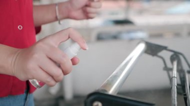 Alkol antiseptiği püskürten, dezenfekte spreyi kullanan, alışveriş arabasında temizlik yapan, el arabası kullanan, Coronavirus salgını sırasında korunan, Covid-19, yüzeyi dezenfektanla temizleyin.