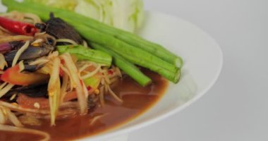 Papaya salatası veya tam baharatlı yengeç ve turşulu beyaz arka planda balık. Popüler Tayland yemekleri.