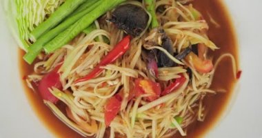 Papaya salatası veya tam baharatlı yengeç ve turşulu beyaz arka planda balık. Popüler Tayland yemekleri.