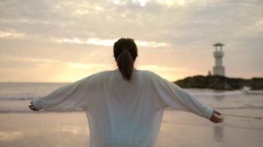 Genç ve ilham verici bir kadın, güzel gündoğumu gökyüzüne karşı ellerini kaldırır. Seyahat sırasında özgürlük ve mutluluk açık havada tatil, yavaş çekim.