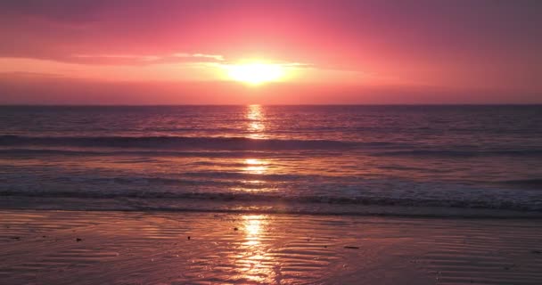 红色的日落笼罩在海滩的海面上 太阳直射地平线 玫瑰金黄的天空 神奇的自然黄昏的天空 — 图库视频影像