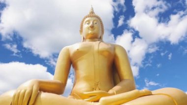 Tayland 'da Altın Buda' nın zaman atlaması. Büyük Buda 'nın parlak altın rengi mavi gökyüzü arka planında güzeldir. Wat Muang, Ang Thong Eyaleti, Tayland