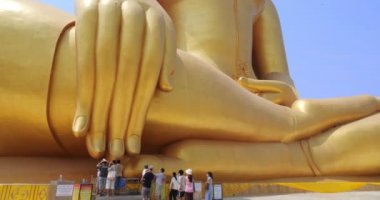Ang-Thong, Tayland - Şubat 2021: Ang-Thong, Tayland 'daki Wat Muang' da altın büyük Buda. İnsanlar büyük altın Buda heykeline saygılarını sunmaya geldiler..