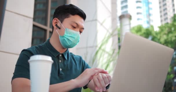 Asijský Muž Zaneprázdněn Ochrannou Lékařskou Maskou Obličeji Pracuje Pomocí Notebooku — Stock video
