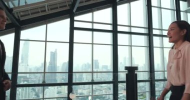 İş ortakları ofis merkezinde tokalaşırken mutlu ve güler yüzlüler.