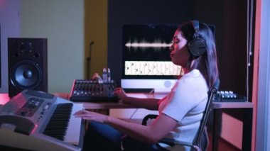 Müzik yapım stüdyosu. Yapımcı. Kayıt stüdyosunda çalışan bir kadın bilgisayar ve mikserle ses kayıt stüdyosunda müzik yaratıyor. Müzik üretimi.