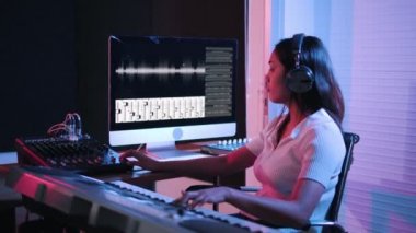 Kayıt stüdyosunda çalışan bir kadın bilgisayar ve mikserle ses kayıt stüdyosunda müzik yaratıyor. Yapımcı Müzik Yapım Stüdyosu.