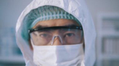 Kendine güvenen Asyalı doktorun portresi. Kameraya bak, yakın plan. Güvenlik gözlüklü ve koruyucu maskeli gözler. Araştırma laboratuvar memuru. 2019 Novel Coronavirus (2019-nCoV), COVID-19, salgın.