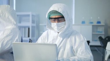 Asyalı bilim adamı analizi laboratuvarda sonuç veriyor. Bilim adamı araştırma yapıyor. Modern Laboratuvarda Deney Yöneticisi..