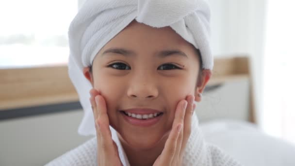 亚洲可爱的小女孩穿着毛巾休息美容护理 看着家里的相机 皮肤护理小孩的美感和魅力 沐浴后穿着浴衣和毛巾的亚洲女孩微笑 — 图库视频影像